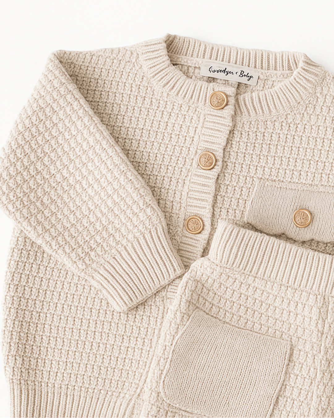 Detalhe do conjunto bege infantil com casaquinho de manga longa e short