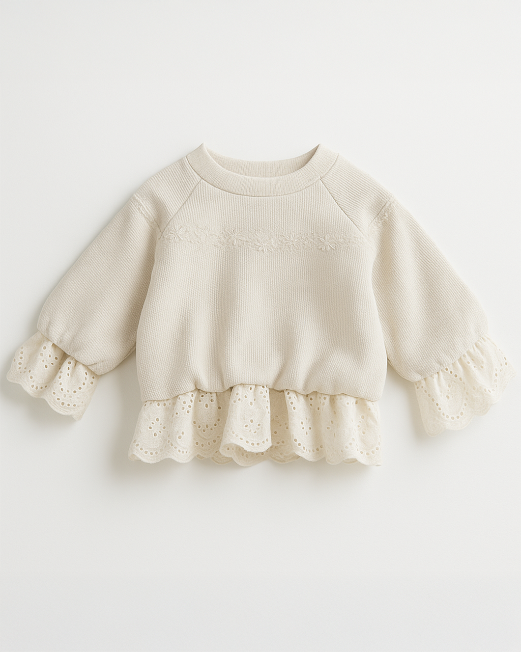 Blusa infantil bege com mangas bufantes, babado na barra e bordado floral delicado