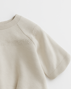 Blusa infantil bege com mangas curtas e delicado bordado floral no peito