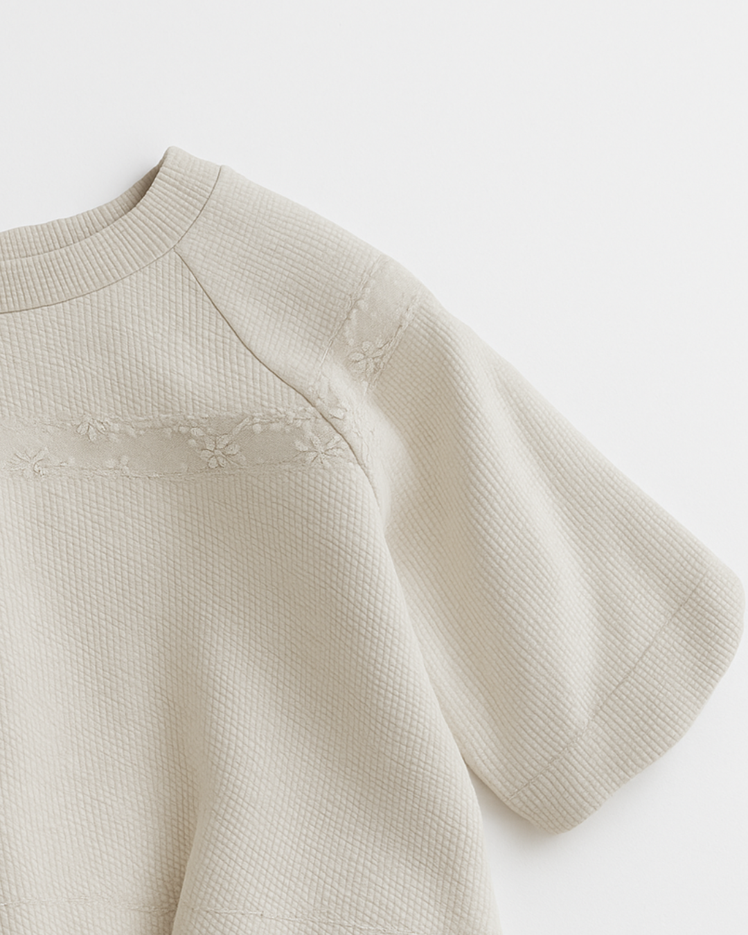 Blusa infantil bege com mangas curtas e delicado bordado floral no peito