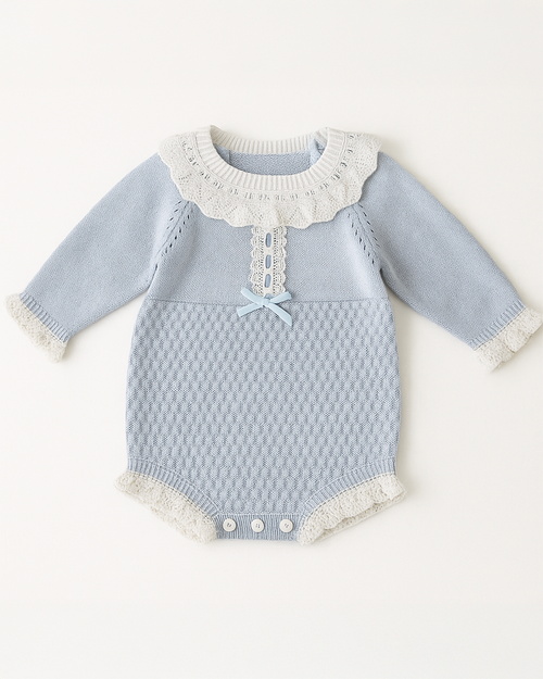 Body azul para bebê em tricô com gola rendada branca e laço decorativo azul claro, combinando delicadeza com sofisticação.