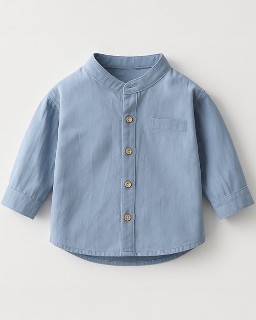 Camisa infantil azul com gola padre e botões frontais, perfeita para looks clássicos e charmosos.