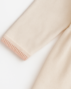 Detalhe do punho do vestido infantil em tricot com acabamento rosado