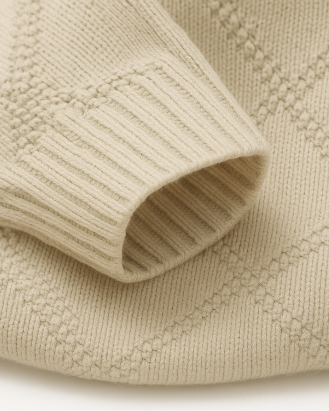 Detalhe do punho em tricot com padrão de diamantes na cor bege