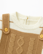 Detalhe do peitoral em tricot com botões e tranças de macacão infantil bege