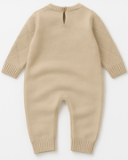 Vista traseira do macacão tricot bege com padrão de diamantes para bebê