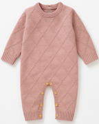 Macacão de bebê em tricot rosa com padrão de diamantes e botões na parte inferior